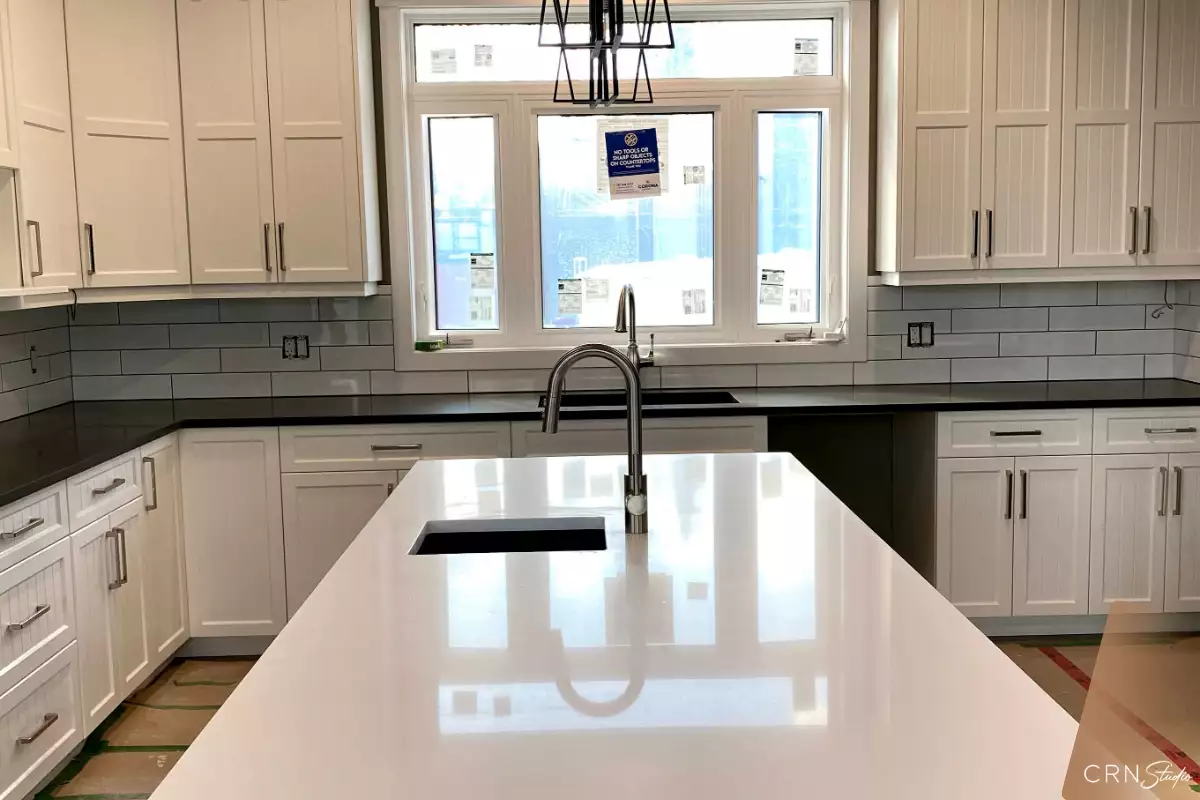 White Shimmer quartz island in a bright shaker-style Okanagan kitchen